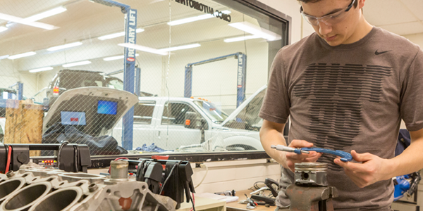 A student works on an engine in the Automotive Lab at Central Maine Community College