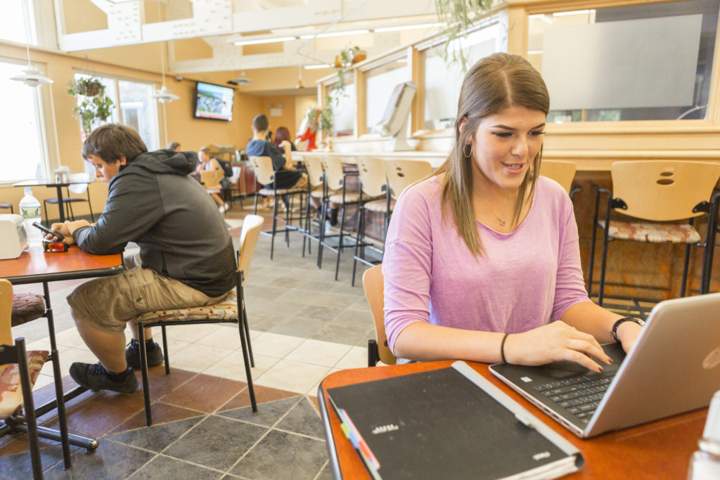 Dining Commons female in pink shirt studying