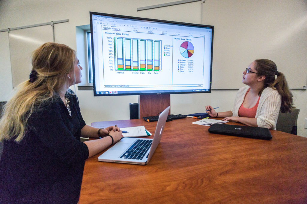 Two women in the Bath Iron Works Business Simulation Lab