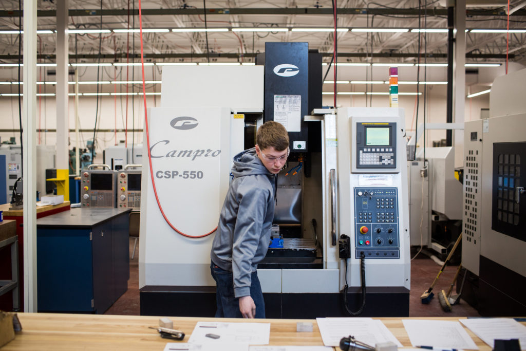 A male student works with a state-of-the-art computer numerical control (CNC) machine in the new Precision Machining Technology lab at Central Maine Community College.