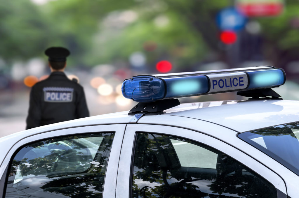 Police car with police officer in the background