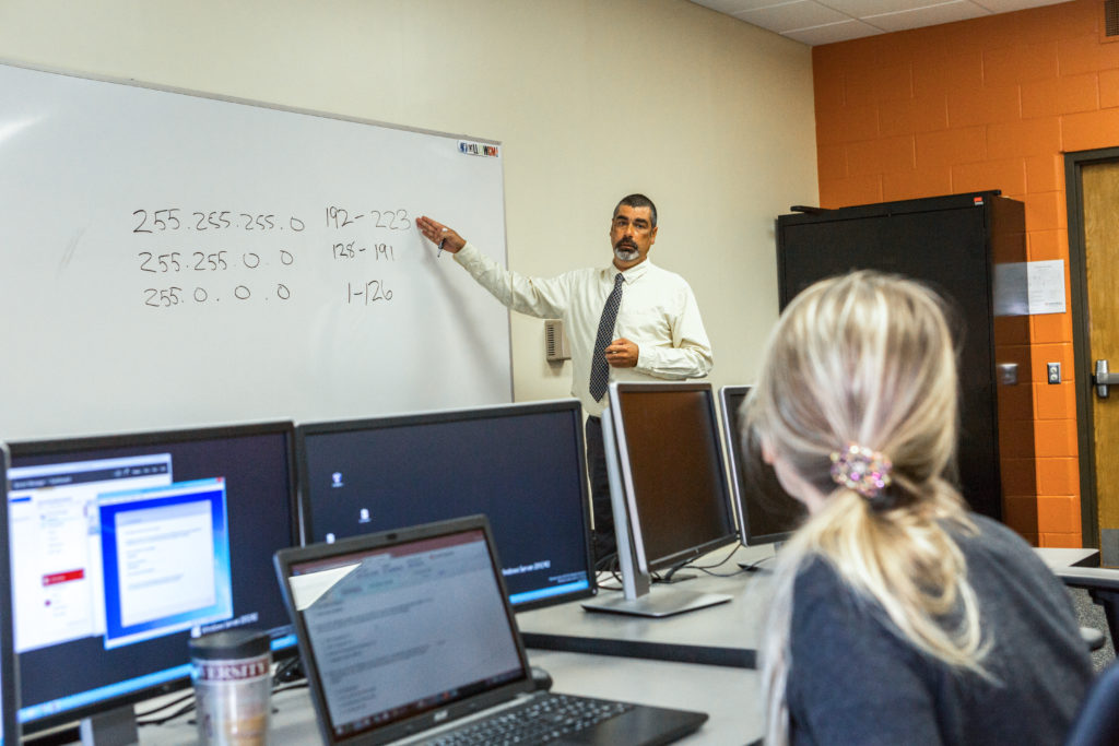 Student pays attention to an instructor during a class in Computer Technology