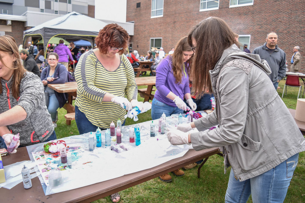 Three females tie-dye tee shirts during an annual Spring Fling party, hosted by Student Senate.