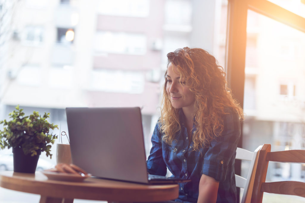 Female sitting at computer in cafe studying