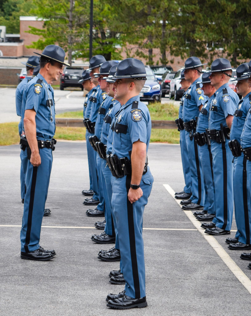 Colonel John Cote, left, chief of the Maine State Police, speaks to troopers during the official Troop B inspection held recently at Central Maine Community College