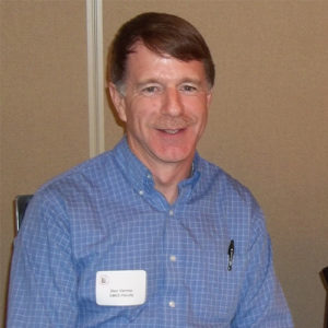 Headshot of Don Varney in a blue buttondown shirt with a pen in his pocket and white nametag.