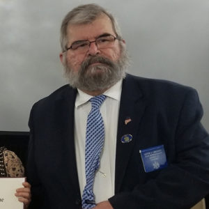 Headshot of Lester Ordway in a black suit, blue tie and white shirt.