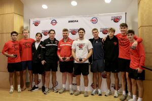 CMCC Men’s Soccer team poses together while displaying their championship rings.