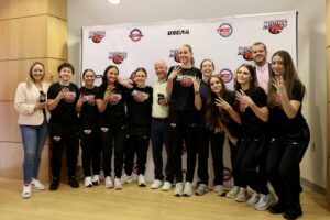 CMCC Women’s Basketball team poses together while displaying their championship rings.